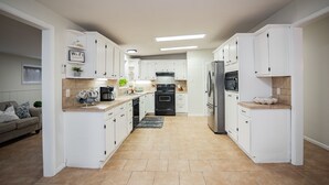 A modern kitchen with white cabinets, a central island, and a built-in oven. - Spacious Vacation Home: Sleeps 16, 1/2 mi to Beach & Boat Ramp - Family Friendly (Port O'Connor)