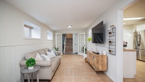 A modern kitchen with a built-in refrigerator, a wooden cabinet, and a TV mounted on the wall. - Spacious Vacation Home: Sleeps 16, 1/2 mi to Beach & Boat Ramp - Family Friendly (Port O'Connor)