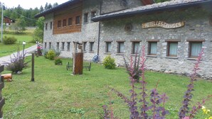 A stone building with a sign reading "HOTEL LES GRANGES." - Hotel Les Granges (La Thuile)