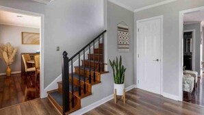 A staircase with wooden steps and black railings leading to a landing.