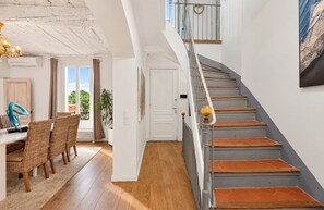 A staircase with wooden steps and a metal railing, leading to an upper floor.