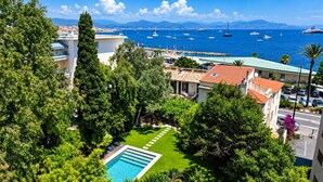 A residential area with a swimming pool, lush greenery, and a view of the sea with boats. - ☀️La plage☀️<br>Classified ⭐️⭐️⭐️⭐️ (Antibes)