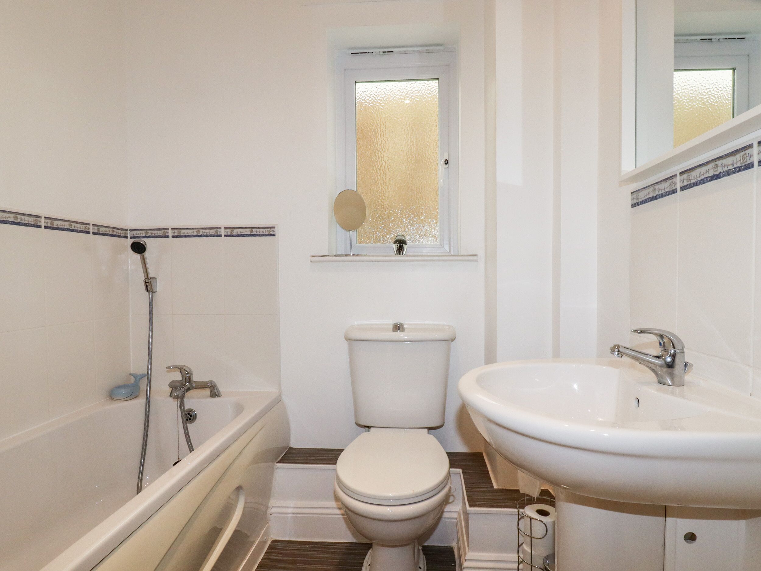 A bathroom with a bathtub, toilet, and sink.
