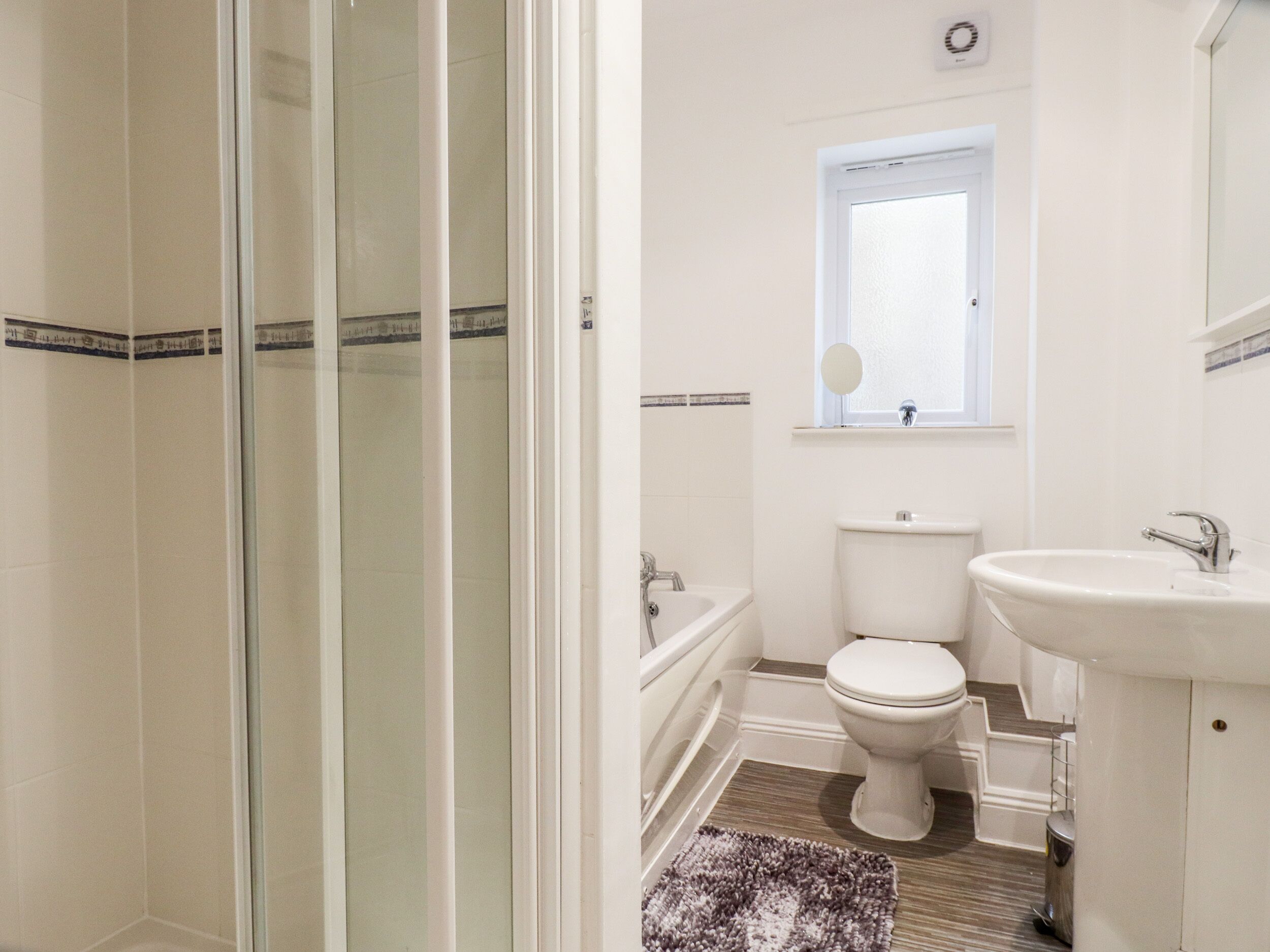 A bathroom with a shower, toilet, and sink.
