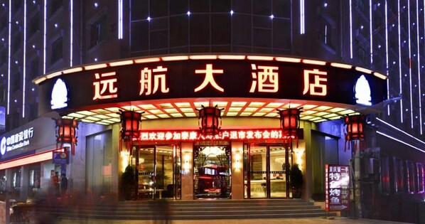 A hotel entrance with illuminated signage and traditional lanterns. - Yuanhang Hotel (Tongren)