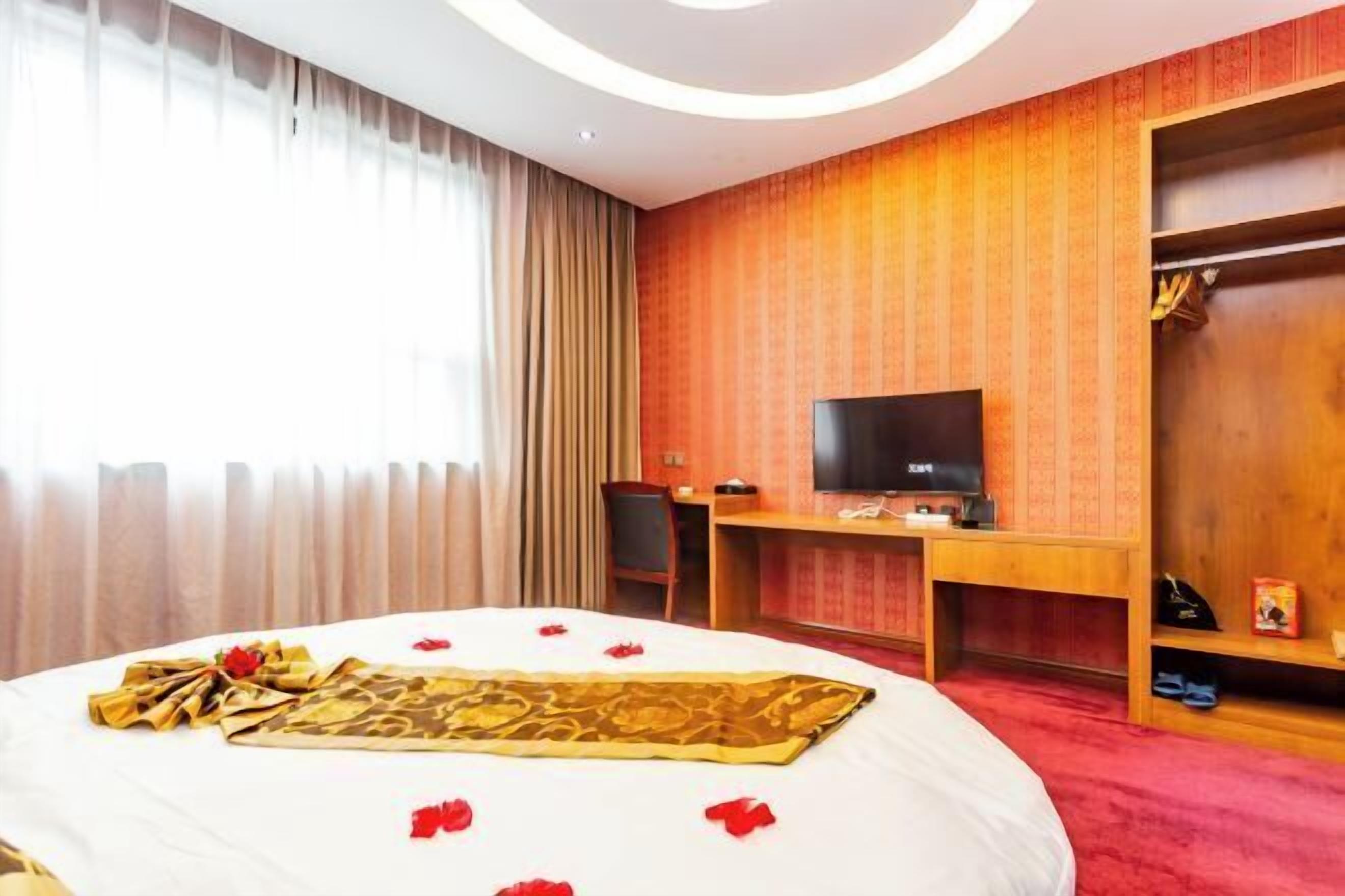 Une chambre d’hôtel équipée d’un lit, d’un bureau, d’une télévision et d’une armoire.