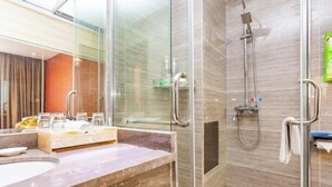 A modern bathroom with a glass-enclosed shower, a marble sink, and a glass shower door. - Yuanhang Hotel (Tongren)