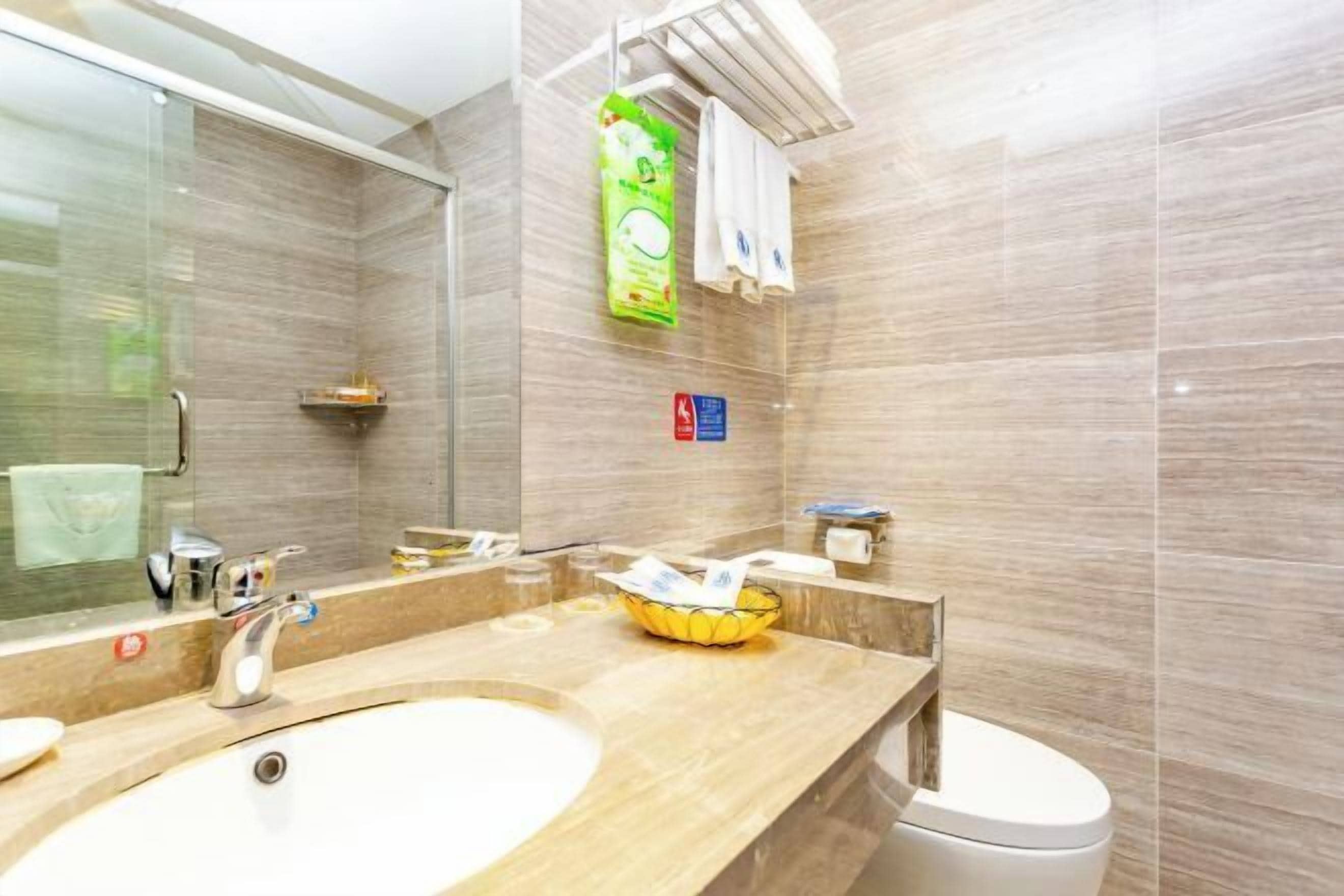 Un baño moderno con lavamanos doble, cabina de ducha con mampara de vidrio y toallero.