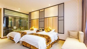 A hotel room with two beds, a seating area, and a large window. - Yuanhang Hotel (Tongren)