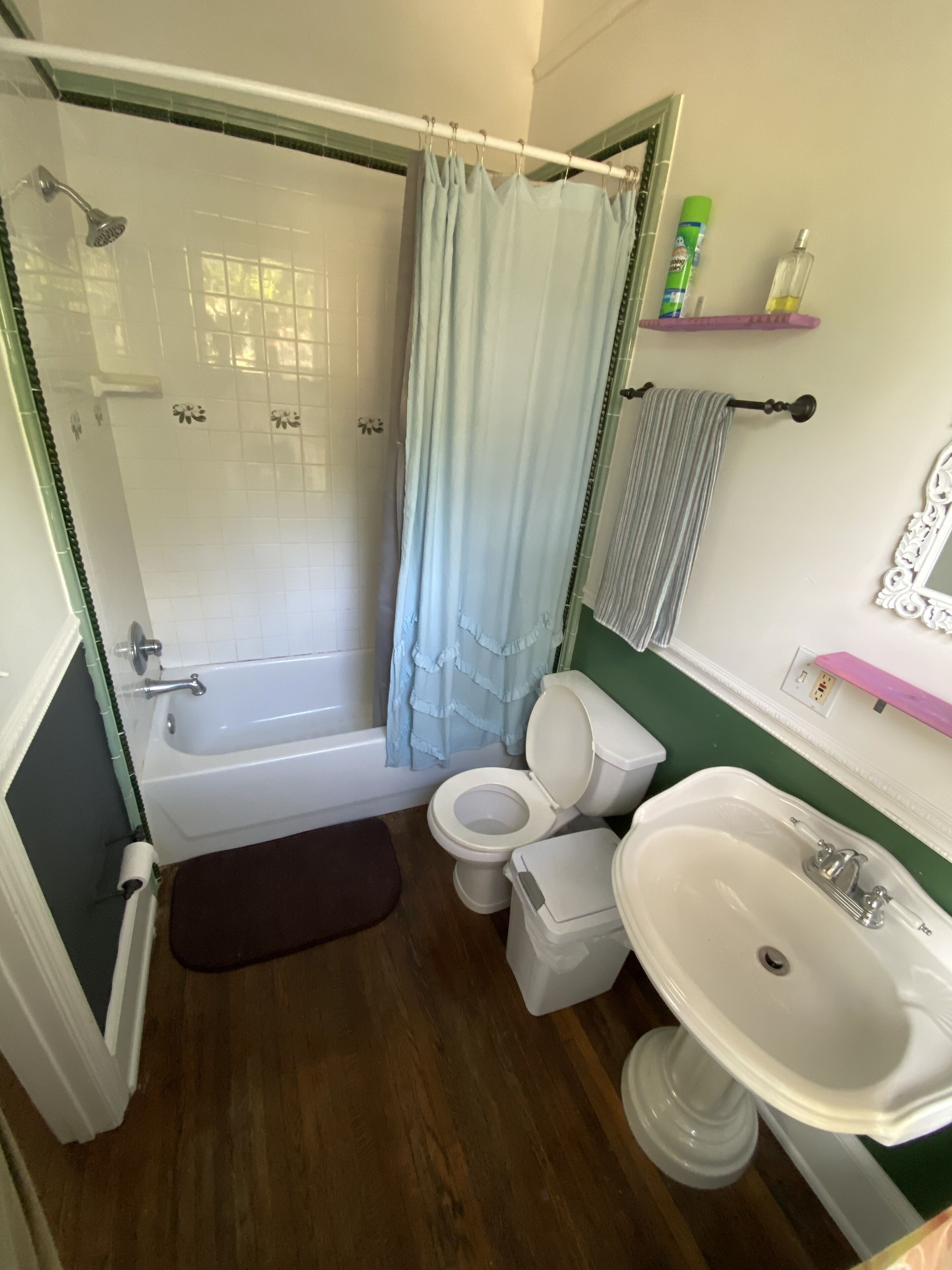 A bathroom with a bathtub, toilet, sink, and shower curtain.