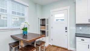 A kitchen with white cabinets, a wooden countertop, and a door with a window.