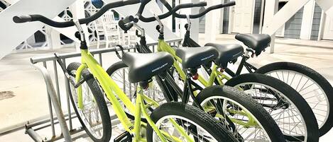 A row of bicycles parked on a metal rack outdoors.