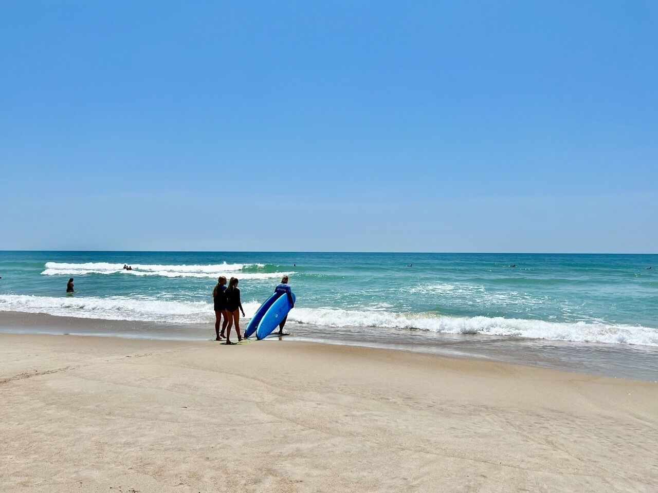 A beach with a sandy shore and ocean waves.