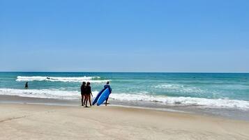A beach with a sandy shore and ocean waves.
