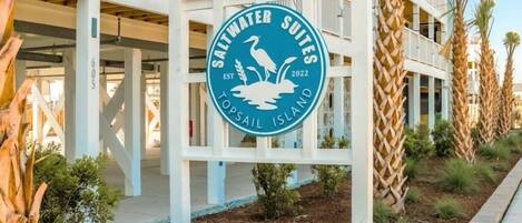 Een meerhoog hotel met een bordje voor Saltwater Suites Top Sail Island.