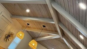 A high ceiling with wooden beams and pendant lighting. - River Rock Cabin - Near Spring River and Main St (Mammoth Spring)