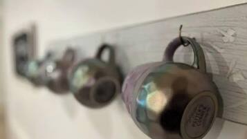 Una hilera de tazas de cerámica colgadas en una pared.