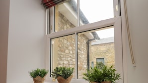 A window with three potted plants on a white ledge. - 1 Hull House Cottage (Skipton)