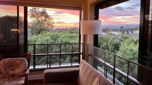 A balcony with a view of a sunset, a sofa, and a chair. - Walk to Poipu Beach • 4BR + Bonus • Pool (Koloa)