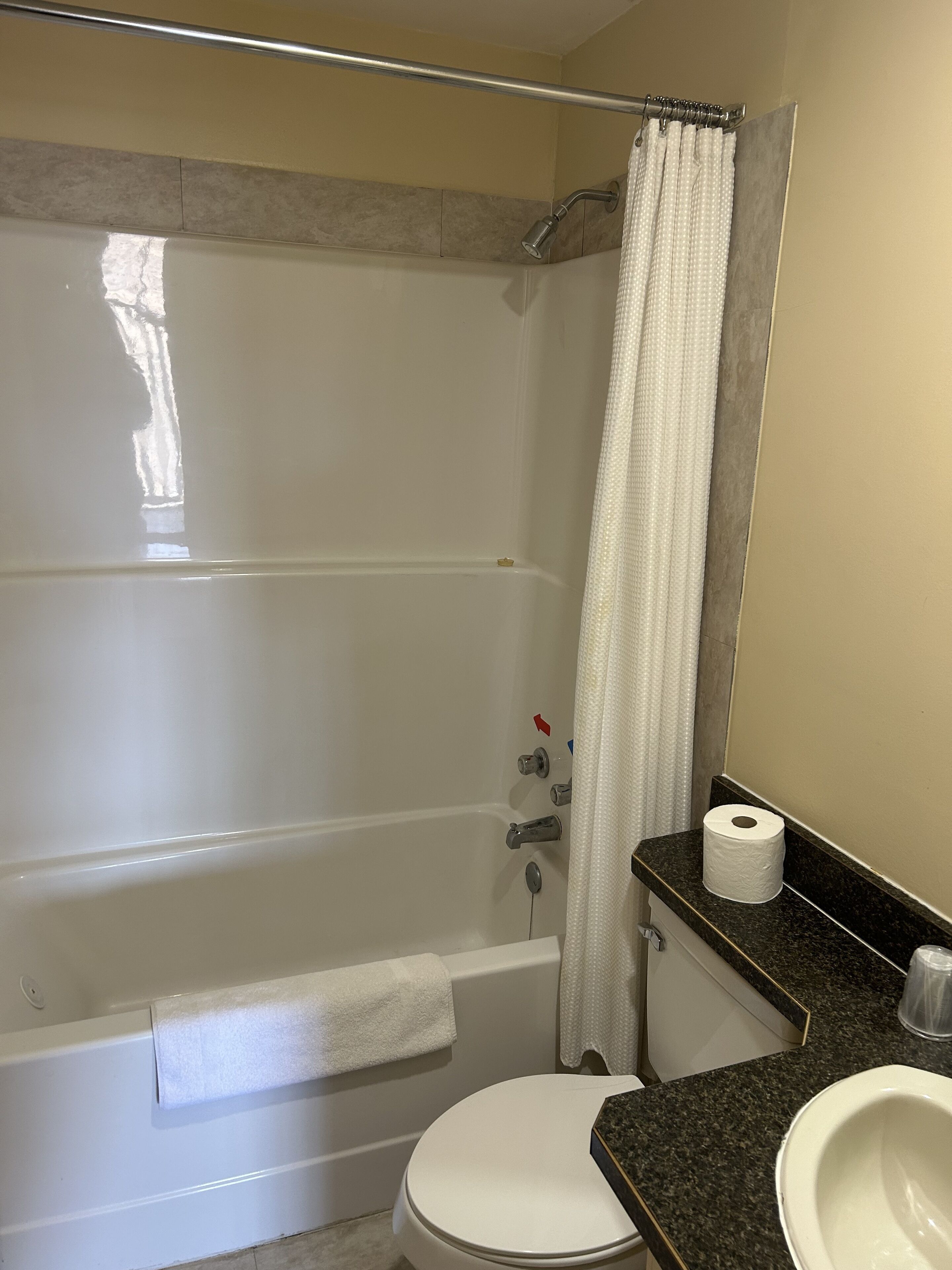 A bathroom with a bathtub, toilet, and sink.