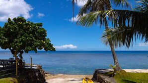A beach with a yellow raft, palm trees, and a clear blue sky. - Merizo Seaside B&B - Unit 2 Coral Suite (Tasi Merizo)