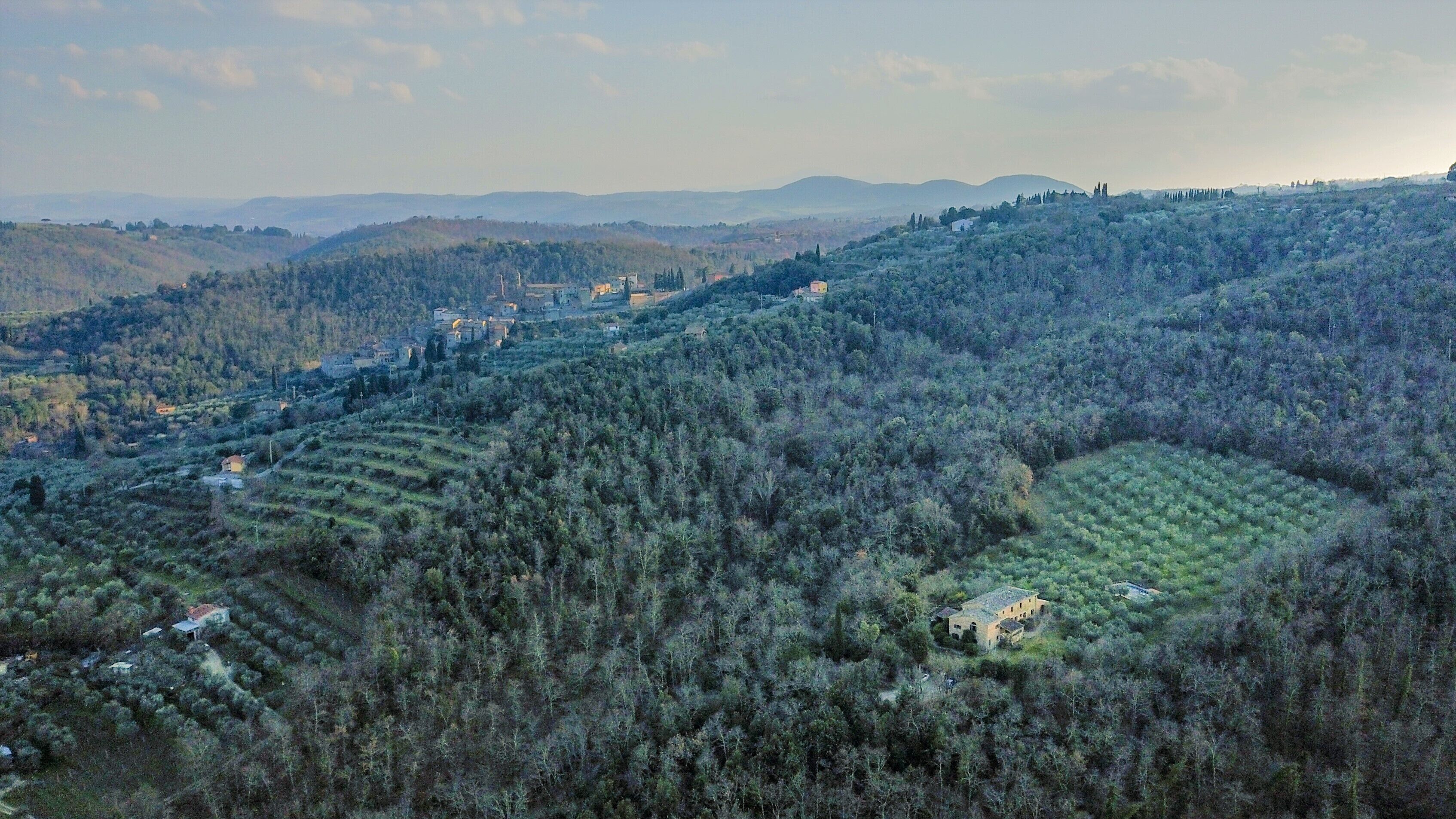 Paisaje montañoso con campos en terrazas y edificios dispersos.