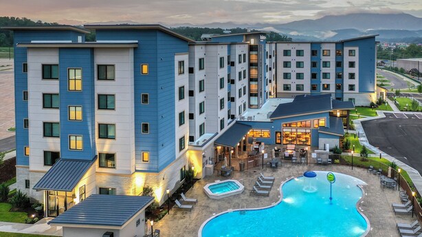 A multi-story hotel with a swimming pool and outdoor seating area. - Residence Inn by Marriott Pigeon Forge (Pigeon Forge)