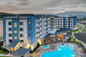 A multi-story hotel with a swimming pool and outdoor seating area. - Residence Inn by Marriott Pigeon Forge (Pigeon Forge)