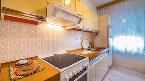 A kitchen with a stove, sink, and a decorative tablecloth. - Anica  A4 -  Apartment with two bedrooms (Baška)