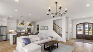 Una sala de estar amplia con un sofá modular, una mesa de centro y un candelabro.