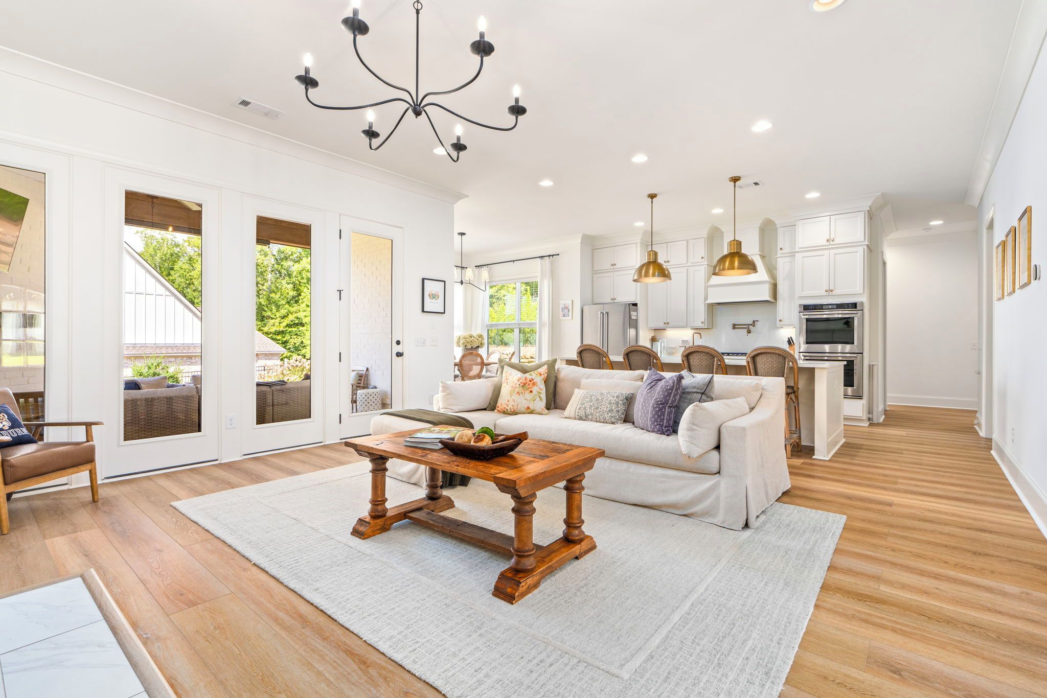 A spacious living room with a wooden coffee table, a sofa, and a dining area with chairs.
