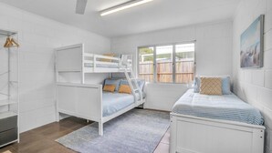 A bedroom with bunk beds, a window, a radiator, and a painting on the wall. - 13 Indigo Avenue - 'Indigo Sands' - Rainbow Beach. Beds made for arrival. Close to beach (Rainbow Beach)