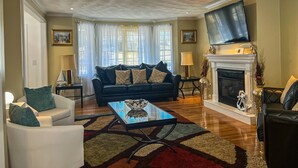 A living room with a fireplace, a sofa, a coffee table, and a TV.