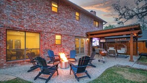 A brick patio with outdoor seating and a fire pit. - Heated Pool-HotTub-Game Room-Fire Pit-Big Backyard (San Antonio)