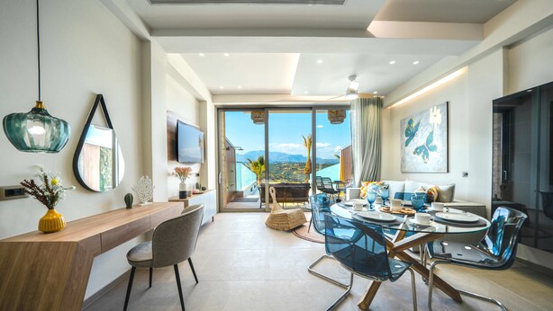 A modern dining area with a glass table, chairs, and a wooden counter. - Oleas Suite Venus & Private Pool (Heraklion)