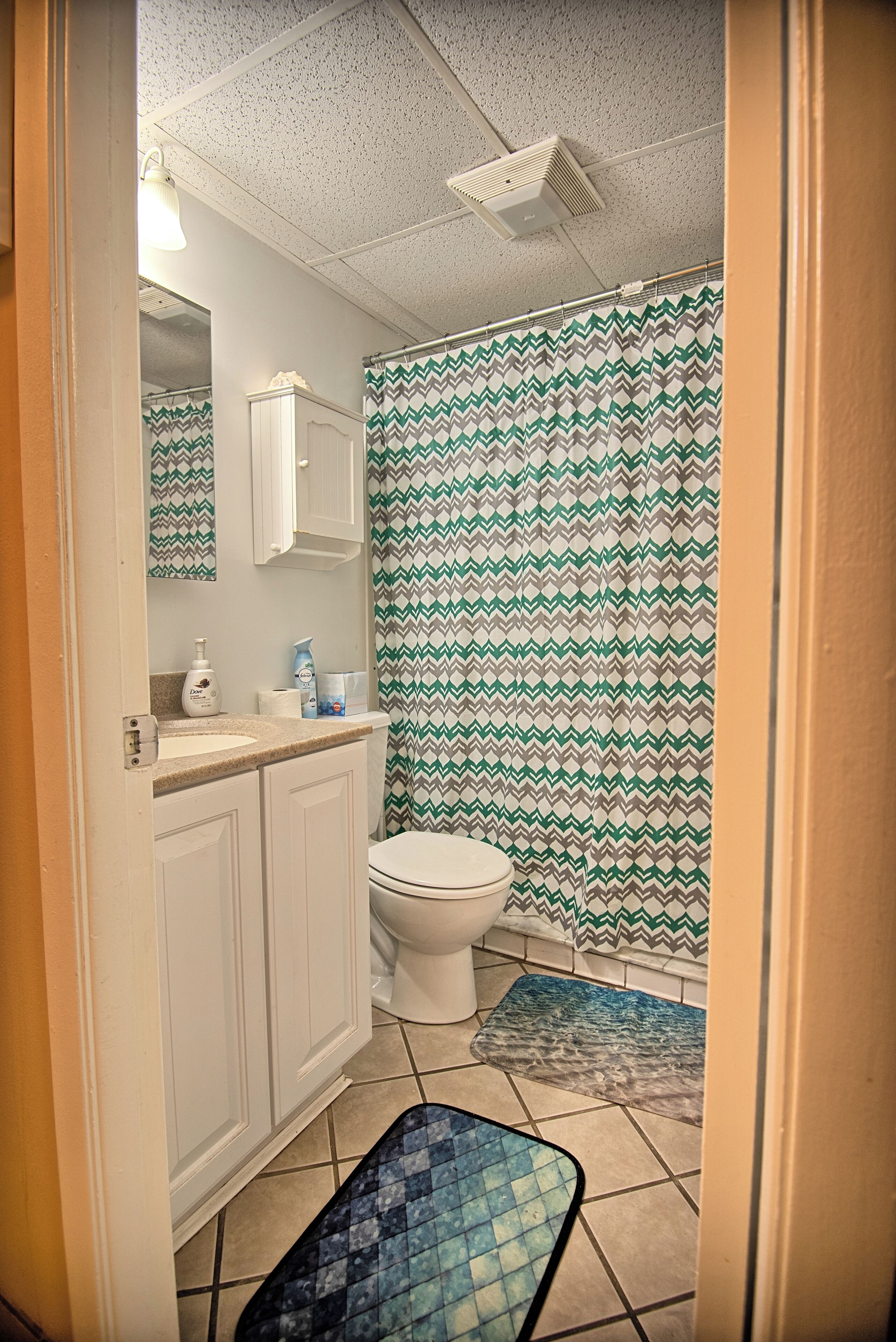 Un baño pequeño con inodoro, lavamanos y cortina de ducha.