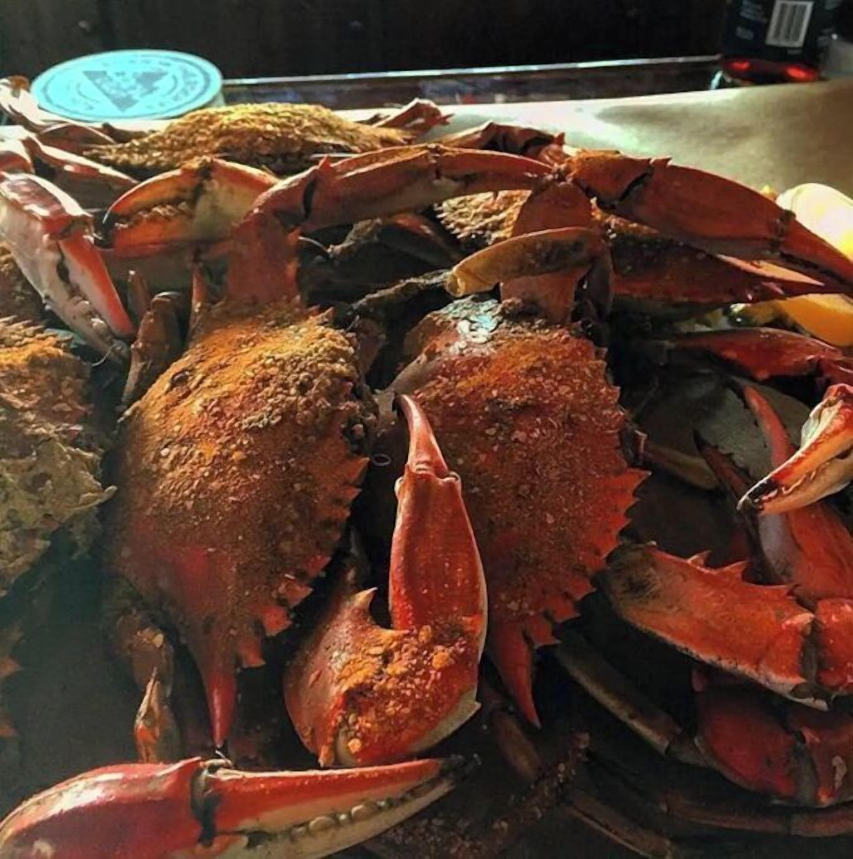 A large group of cooked crabs piled together.