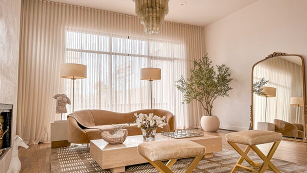 A modern living room with a beige sofa, a coffee table, and a large mirror. - Kirby Haus ·Modern Luxury· West U· RiceVillage · sleeps16 ·EV 🚗🔌 •3900sqft ⭐️⭐️⭐️⭐️⭐️ (Houston)