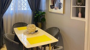 A dining area with a table, chairs, and a decorative piece on the wall. - Exotic 2 Bedrooms Apartment (Accra)