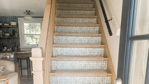 A staircase with patterned carpet leading to a landing. - Gypsy Cottage · Walkable · Pet-Friendly PSJ (Port St. Joe)