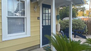 A yellow building with a blue door and a porch. - Gypsy Cottage · Walkable · Pet-Friendly PSJ (Port St. Joe)