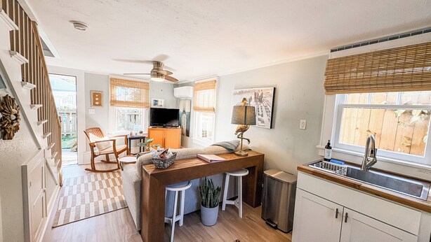 A compact kitchen with a dining area, a built-in stove, and a window with blinds. - Gypsy Cottage · Walkable · Pet-Friendly PSJ (Port St. Joe)