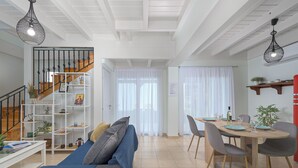 A modern living room with a staircase, a dining area, and a kitchen. - Villa Christalia. Cozy family Villa 300m from the beach with swimming pool. (Κολύμπια)
