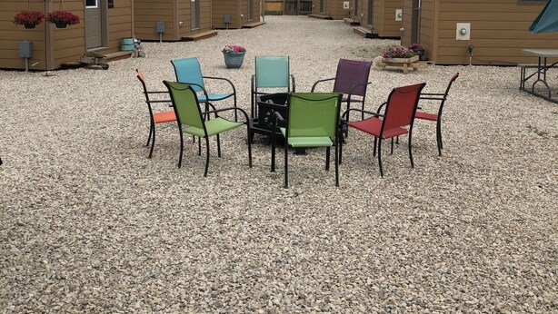 Une rangée de cabanes dotées d’espaces extérieurs aménagés et dont le sol est recouvert de gravier.