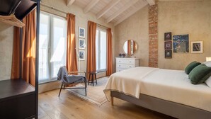 Un dormitorio con cama, cómoda, silla y escritorio.