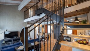 Ein modernes Wohnzimmer mit einer geschwungenen Treppe, einem Essbereich und einer Küche mit Holzböden.