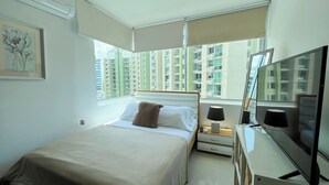 A hotel room with a bed, bedside table, lamp, and a TV. - Accommodation with views in Costa del Este 6 (Panama)