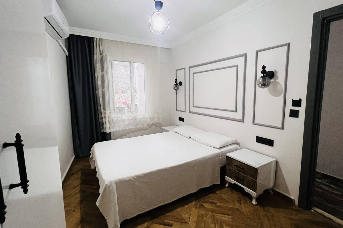 A bedroom with a bed, bedside table, and a wardrobe.