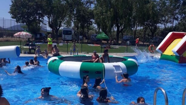 Una piscina con estructuras inflables y un tobogán.
