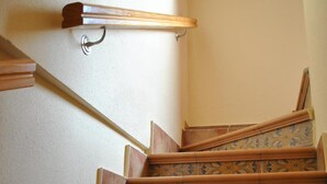 Una escalera con elaborados diseños de azulejos y barandilla de metal.